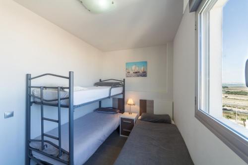 拉马他Aqua Nature 27D的一间卧室设有两张双层床和一扇窗户。