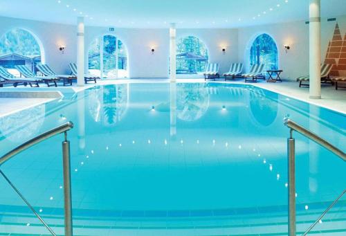 坎德施泰格多尔登峰森林酒店的大楼内一个蓝色的大型游泳池