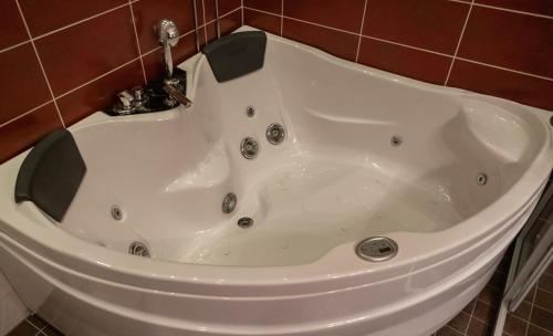 鲁卡Hotel Rukatonttu的浴室内设有带水龙头的白色浴缸