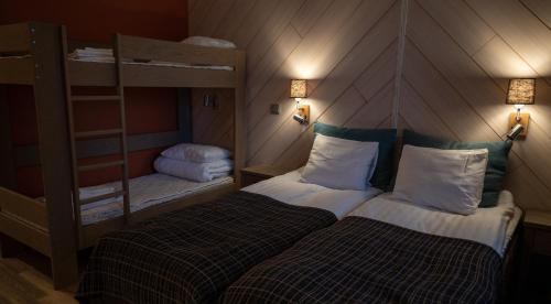 鲁卡Hotel Rukatonttu的小房间设有两张双层床和梯子