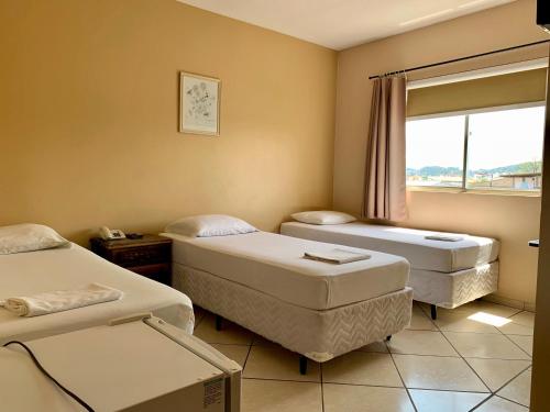 帕罗卡Hotel Pontal的一间医院间,设有两张床和窗户
