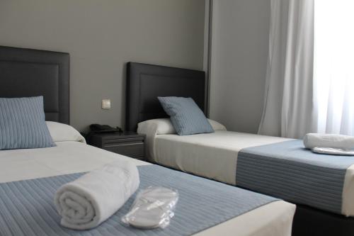 马德里巴拉哈斯广场酒店的酒店客房,配有两张带毛巾的床