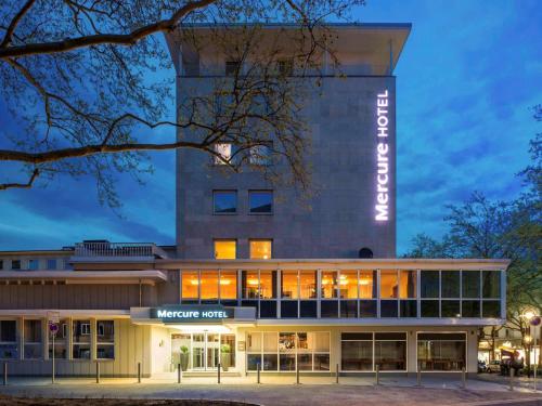 多特蒙德Mercure Hotel Dortmund Centrum的夜间 ⁇ 染了这个万国酒店