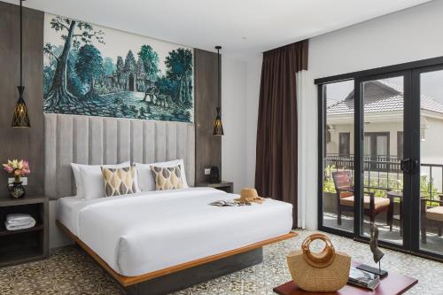 暹粒Siem Reap Palace Hotel & Spa的一间带大床的卧室和一个阳台