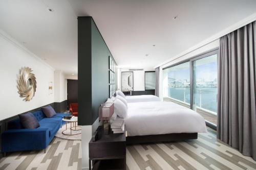 金浦Hotel Marinabay Seoul的一间卧室配有一张大床和一张蓝色的沙发