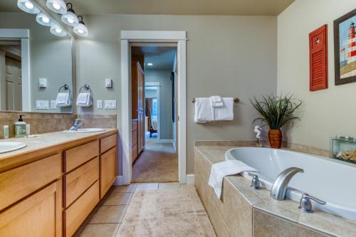弗洛伦斯River Vista的带浴缸、两个盥洗盆和镜子的浴室