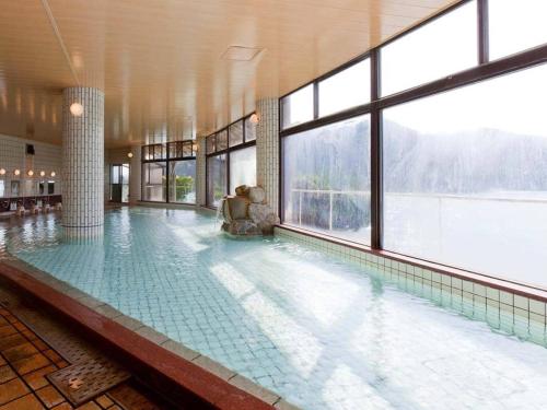 胜浦市Kumano-bettei Nakanoshima的一座大型游泳池,位于一座带窗户的建筑内