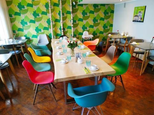 波恩莱茵兰德酒店的用餐室配有长桌和五颜六色的椅子