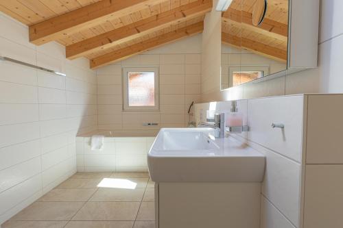 维尔德斯韦尔Chalet Gousweid- Jungfrau Apartment的白色的浴室设有水槽和镜子