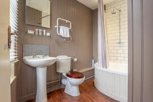 坎特伯雷牧羊人尼姆米勒斯纹章旅馆的浴室配有卫生间、盥洗盆和浴缸。