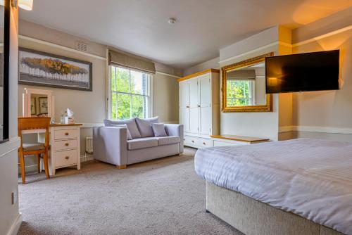 坎特伯雷牧羊人尼姆米勒斯纹章旅馆的一间卧室配有一张床、一张沙发和一台电视