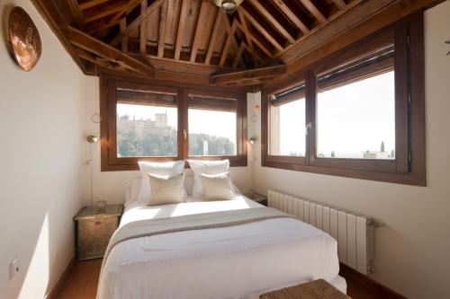 格拉纳达卡萨邦博酒店的卧室配有一张白色大床和两个窗户