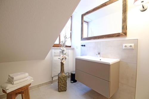 奥泊维森塔尔Aparthotel Deutscher Kaiser Ferienwohnungen的浴室设有水槽和花瓶