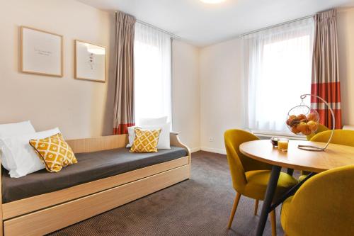 里尔Appart'City Confort Lille - Euralille的酒店客房带一张床、一张桌子和椅子