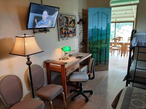 纽沃阿雷纳尔Marita's Bed and Breakfast的客房设有书桌和墙上的电视。