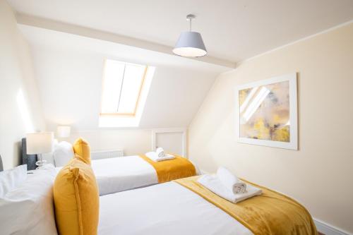 霍兹登Velvet 2-bedroom apartment, Clockhouse, Hoddesdon的卧室设有2张床和白色的墙壁。