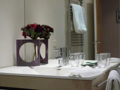 巴黎Gorgeous Paris St Germain des Près的浴室水槽内装有镜子和鲜花