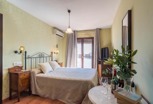 米哈斯萨尔瓦多埃斯库多米哈斯旅舍的一间卧室配有一张床、一台电视和一张桌子