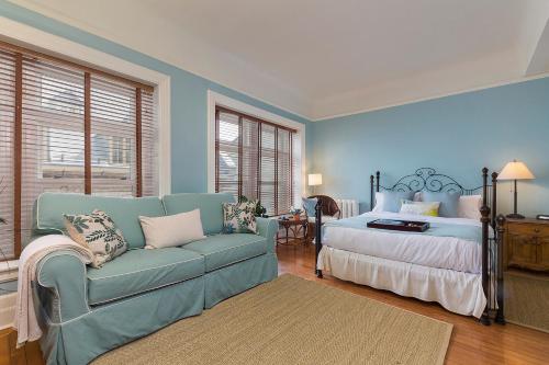 魁北克市Les Immeubles Charlevoix - Le Perchoir 1018的蓝色的卧室配有床和沙发