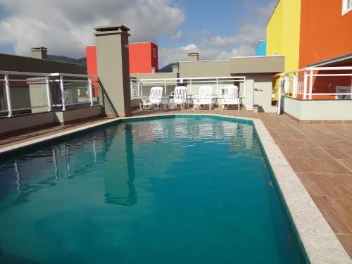 乌巴图巴LINDO APTO COM PISCINA, SAUNA, SALÃO DE JOGOS, WIFI, AR CONDICIONADO e SACADA GOURMET NO ITAGUA的建筑物一侧的游泳池