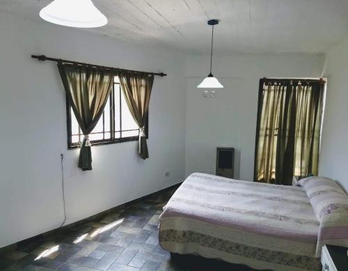 莫龙Alojamiento Entero con Excelente Ubicación的一间卧室设有一张床和两个窗户。