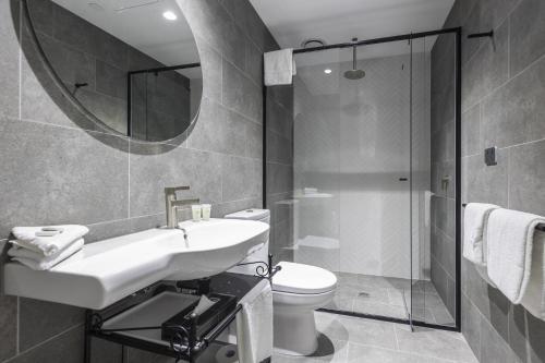 墨尔本Q Squared Serviced Apartments的一间带水槽、卫生间和镜子的浴室