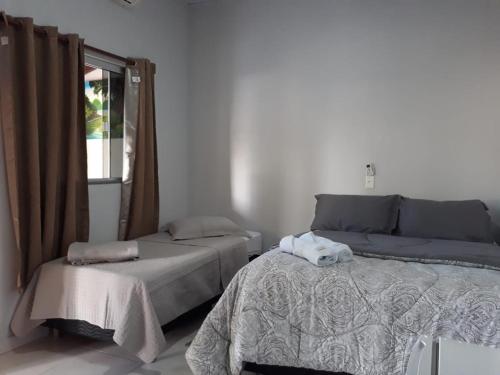 皮雷诺波利斯Suites do Ratinho的一间卧室设有一张床和一个窗口