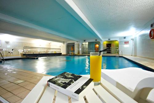 普里茅斯New Continental Hotel; Sure Hotel Collection by Best Western的坐在游泳池前的长凳上喝一杯