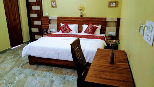 达兰萨拉Sakura Guest House的一间卧室配有一张大床和一张木桌