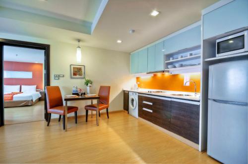 曼谷Aspen Suites Hotel Sukhumvit 2的厨房配有桌椅和1张床
