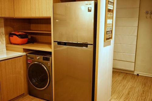 三宝垄Graha Padma Avonia的厨房里配有不锈钢冰箱,厨房里配有洗衣机