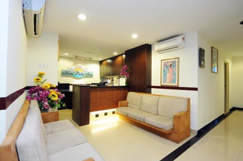 安邦Palm Inn Ampang Point的客厅配有沙发和桌子