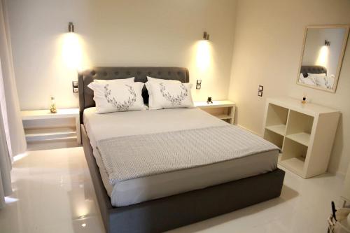 沃洛斯Hope home的一间卧室配有带白色床单和枕头的床。