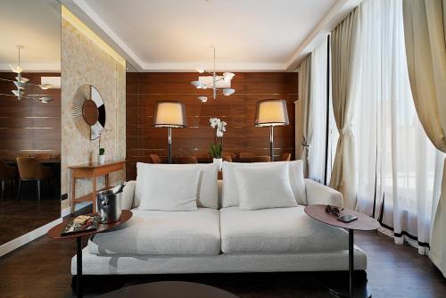 贝尔格莱德玛吉斯迪克酒店的客厅配有白色的沙发和桌子
