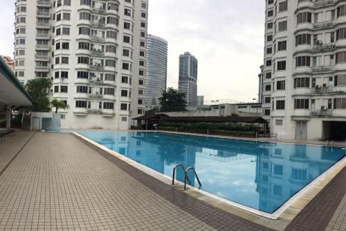 八打灵再也Cozy Kelana Jaya Semi-D Apt near Mall, College & Hospital的两个高楼中间的一个游泳池