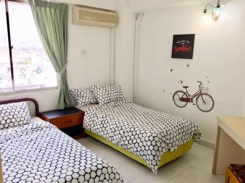 八打灵再也Cozy Kelana Jaya Semi-D Apt near Mall, College & Hospital的卧室配有两张床,墙上有一辆自行车