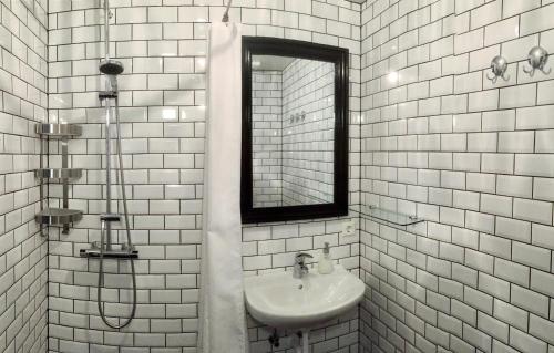 Tungulending唐古伦丁住宿加早餐旅馆的白色瓷砖浴室设有水槽和镜子