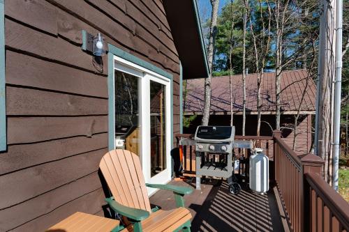 普莱西德湖Cobble Mountain Lodge的一个带两把椅子的庭院和房子内的烧烤设施