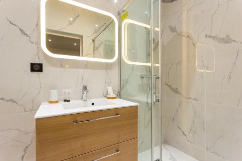 巴黎CMG Montmartre/ Marché Saint-Pierre的浴室配有盥洗盆和带镜子的淋浴