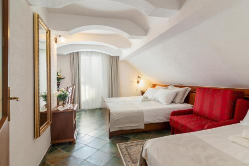 戈雷尼斯卡地区采尔克列Jagodic Garni Hotel的酒店客房,设有两张床和一张红色椅子