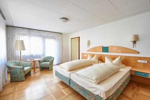 Wachenroth咖斯特豪夫维奇林酒店的一间卧室配有一张大床和一张桌子及椅子