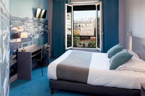 巴黎蒙帕纳斯敖德萨酒店的一间卧室配有一张床、一张书桌和一个窗户。