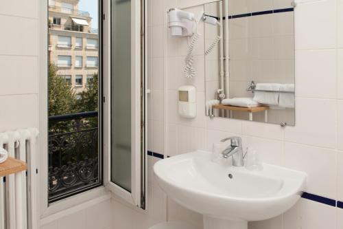 巴黎蒙帕纳斯敖德萨酒店的白色的浴室设有水槽和窗户。