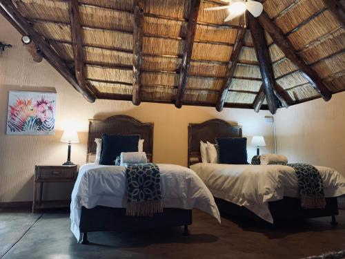 贝拉贝拉Makhato Bush Lodge 111的配有木天花板的客房设有两张床。