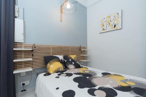 土伦L'Olivaroise的一间卧室配有一张黑色和黄色毯子的床