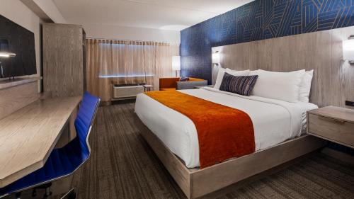 拉科尼亚兰德马克客栈的酒店客房设有一张大床和一张书桌。