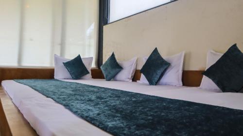 纳西克Jungle Safari Resort & Holiday Villa的一张带白色枕头的大床和大窗户