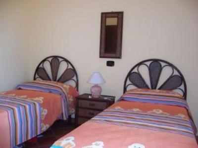 科克瑞诺Villa Laura的一间卧室配有两张床和一张带台灯的桌子