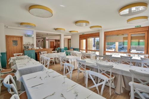 RasinesLa Posada de Ojebar Nórdica的餐厅设有白色的桌椅和窗户。