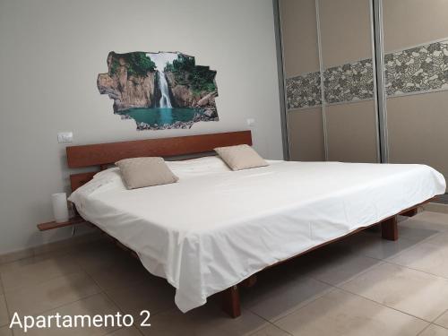 大加那利岛拉斯帕尔马斯Apartamento Kings Vegueta的卧室内的一张大床,墙上挂着瀑布画